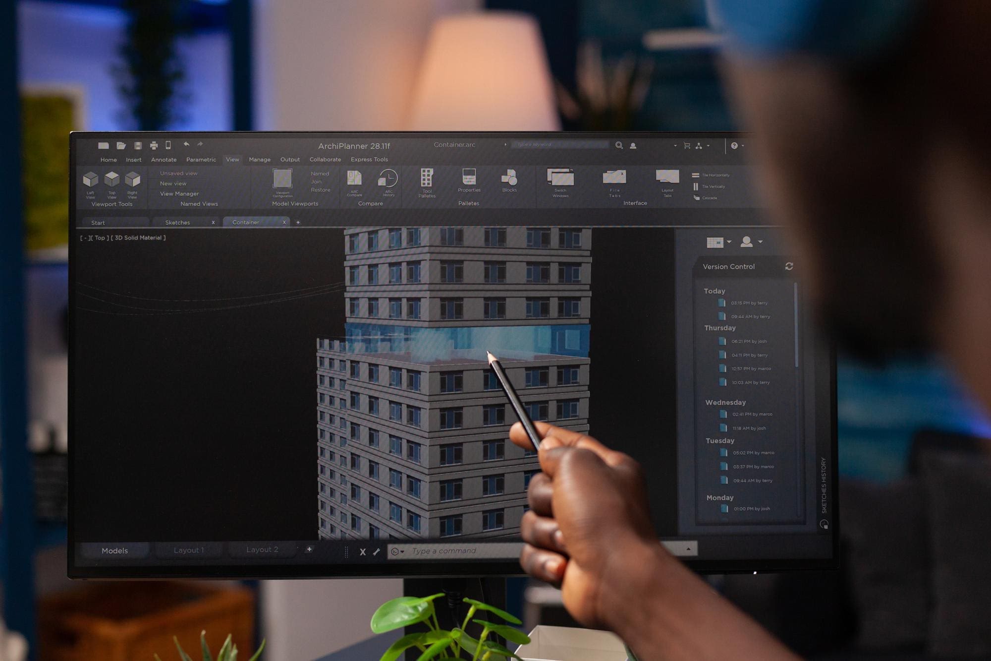 Homem apontando para tela do computador mostrando o projeto BIM de uma construção.