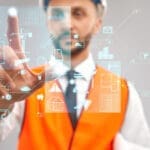 Homem com colete laranja clicando na lente e selecionando elementos da construção civil.