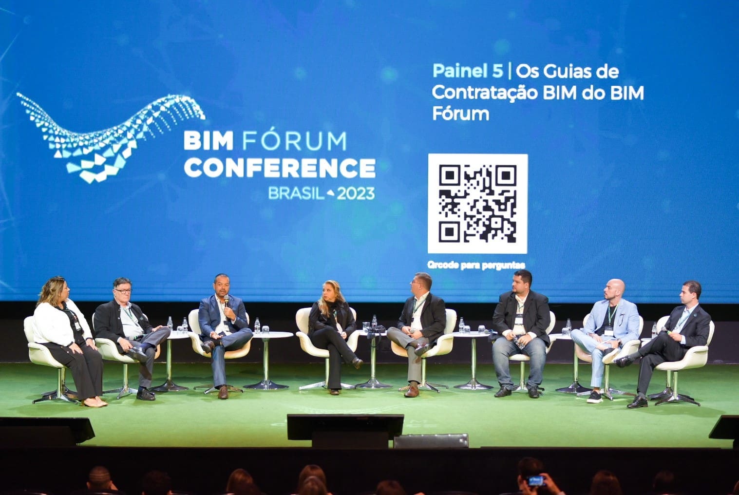Imagem de oito pessoas sentada na frente de um painel sobre BIM Fórum Conference.