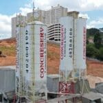 Imagem da concreteira Concreserv, vários cilíndos distribuídos pela imagem, com um fundo de terra e céu.