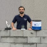 Representante da Ibratin com troféus de premiação, blocos sustentáveis e embalagem da Textura Biotex, simbolizando inovação e economia circular no setor de tintas.
