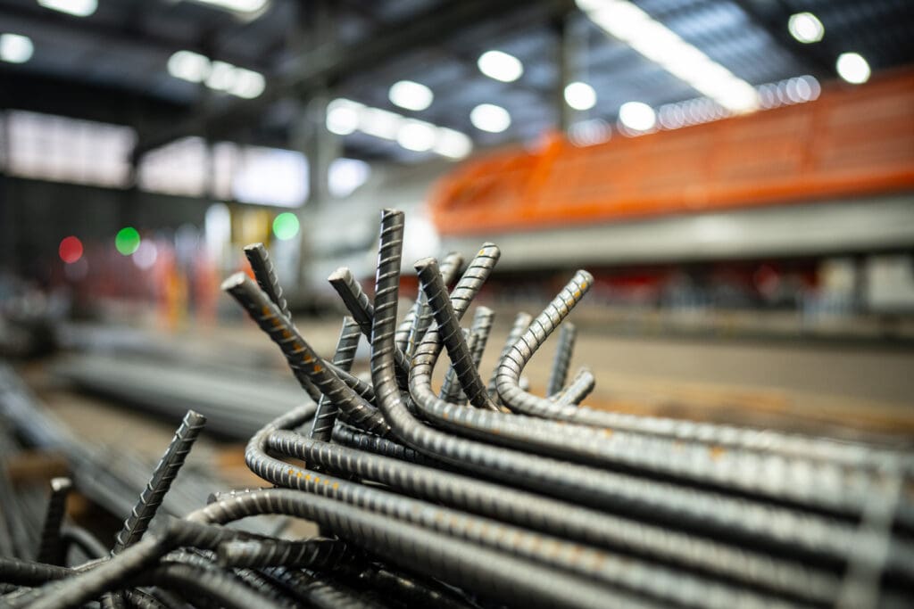 Barras de aço cortadas e dobradas com precisão em ambiente industrial, prontas para uso em obras.