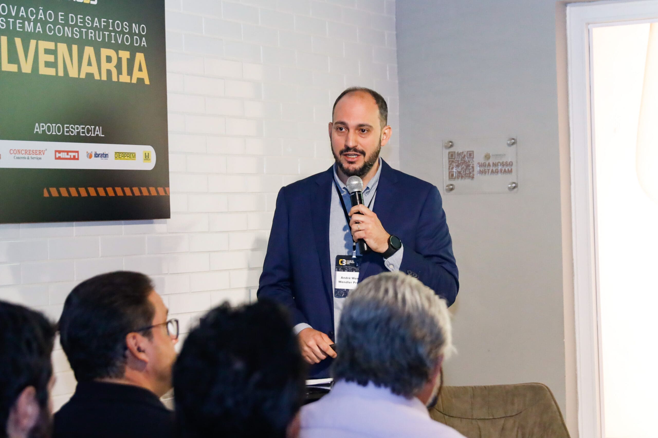 André Wendler apresenta palestra sobre projeto colaborativo em alvenaria durante o evento Conexões C3, diante de uma plateia atenta.