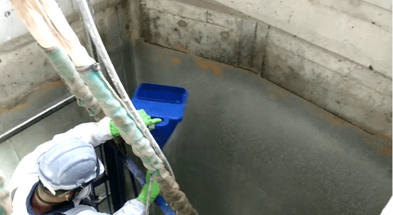 Técnico aplicando produto antimicrobiano em parede de concreto para aumentar a durabilidade em estação de tratamento de efluentes.