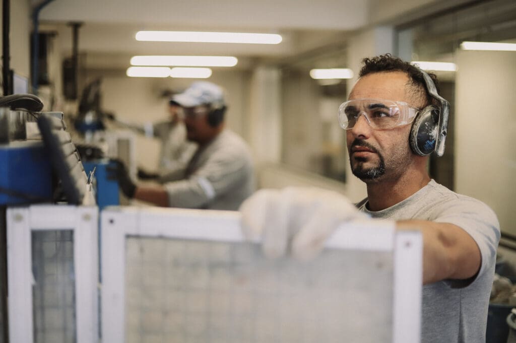 Profissional da Concreserv com equipamentos de proteção individual realiza ensaio de controle tecnológico do concreto em laboratório, focado em qualidade e segurança.