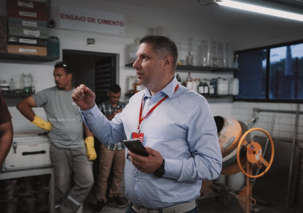 Dr. Carlos Britez conduz explicação técnica sobre concreto de baixo carbono em laboratório de ensaios de cimento.
