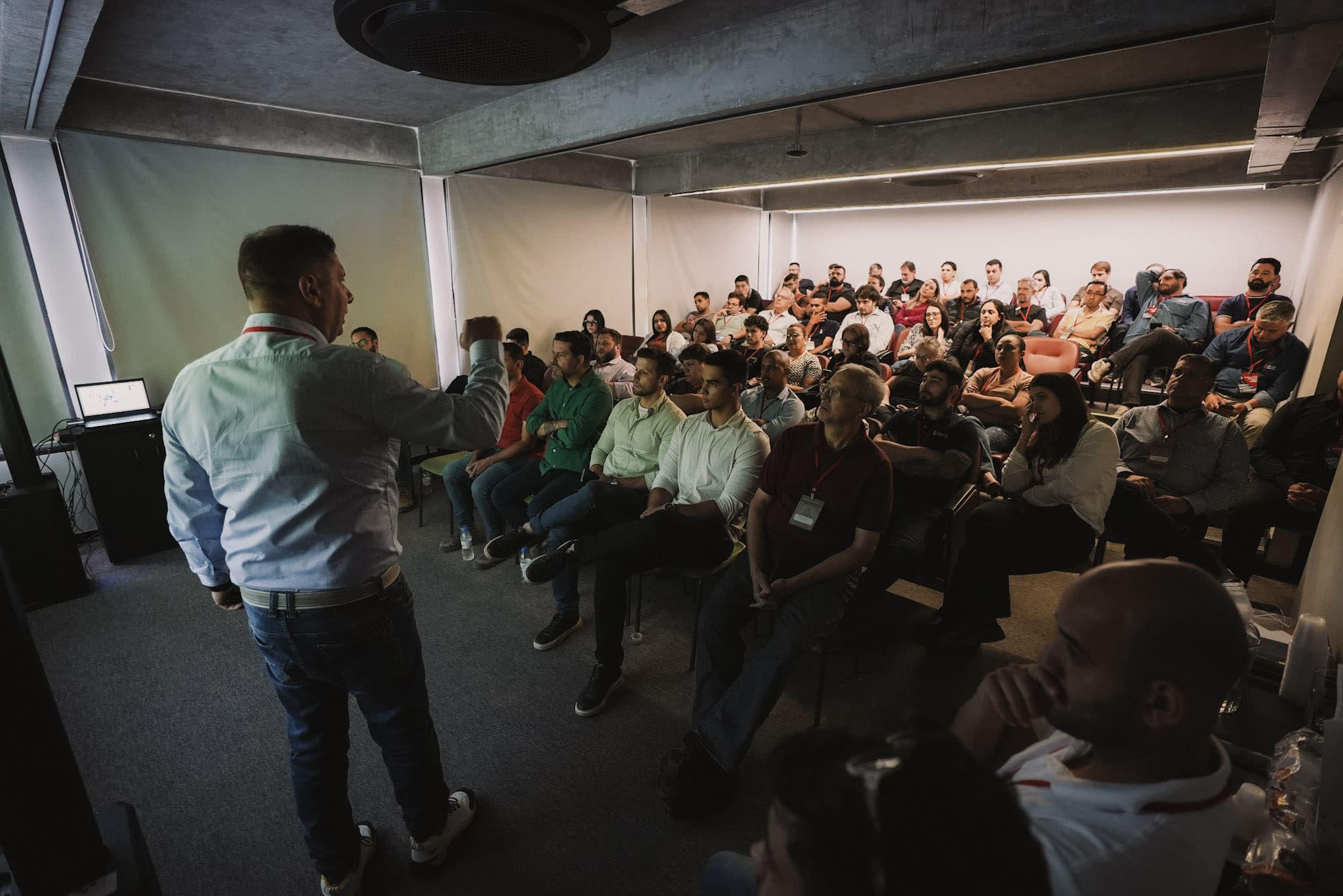 Palestrante conduzindo apresentação para um auditório cheio durante encontro técnico da Concreserv sobre inovação e sustentabilidade no concreto.