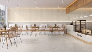 Cafeteria contemporânea com piso Portobello Lombarda Viva Avorio 120x120 cm, mesas e cadeiras de madeira, iluminação suave e decoração minimalista.
