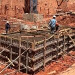 Equipe técnica da Servter SP executando a montagem de bloco de fundação em obra de grande porte, com armação e escoramento em destaque.