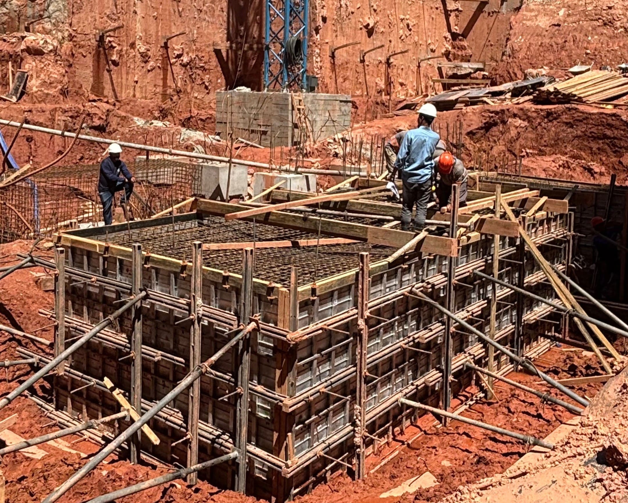 Equipe técnica da Servter SP executando a montagem de bloco de fundação em obra de grande porte, com armação e escoramento em destaque.
