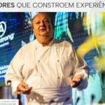Chef renomado apresenta palestra no evento Gourmet Experience do C3, unindo gastronomia e construção civil, com painel de patrocinadores ao fundo.