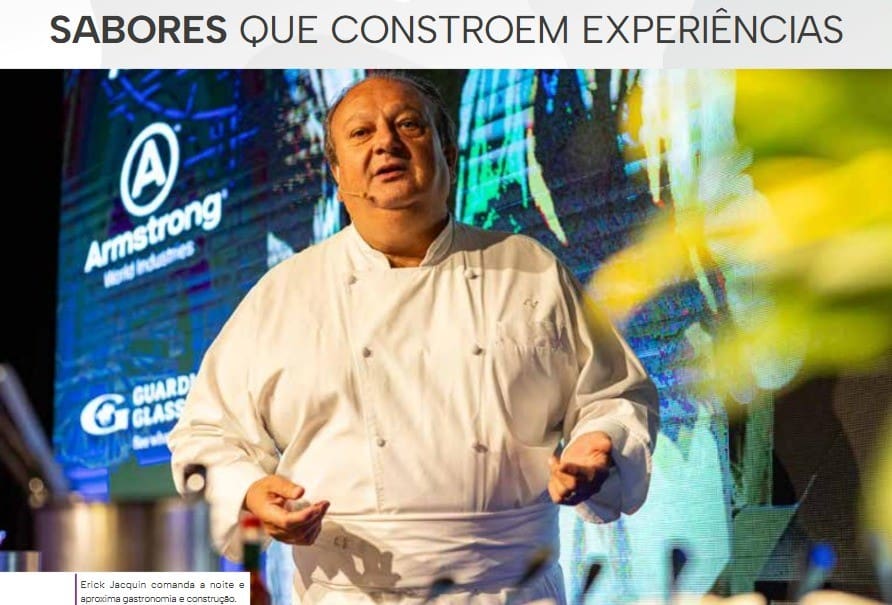 Chef renomado apresenta palestra no evento Gourmet Experience do C3, unindo gastronomia e construção civil, com painel de patrocinadores ao fundo.