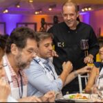 Chef interage com executivos durante jantar de networking do Hub C3, promovendo integração e experiências exclusivas no setor da construção civil.
