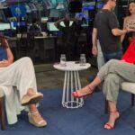 Roberta Bigucci sendo entrevistada por Christiane Pelajo no estúdio da TV Times Brasil durante o quadro Protagonistas, com ambiente moderno e profissionais ao fundo.