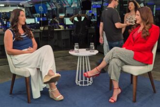 Roberta Bigucci sendo entrevistada por Christiane Pelajo no estúdio da TV Times Brasil durante o quadro Protagonistas, com ambiente moderno e profissionais ao fundo.
