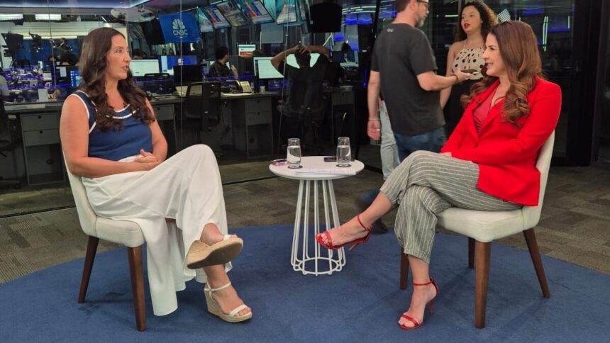 Roberta Bigucci sendo entrevistada por Christiane Pelajo no estúdio da TV Times Brasil durante o quadro Protagonistas, com ambiente moderno e profissionais ao fundo.