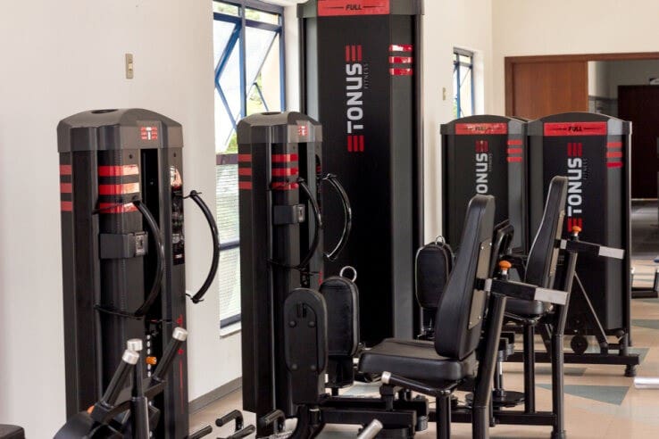Equipamentos profissionais de musculação em academia do condomínio, com máquinas multifuncionais e layout compacto e organizado