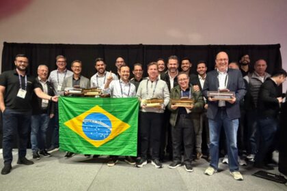 Equipe brasileira da Concreserv e parceiros celebram premiação internacional no Golden Trowel Awards 2025, em Las Vegas, segurando troféus e a bandeira do Brasil.