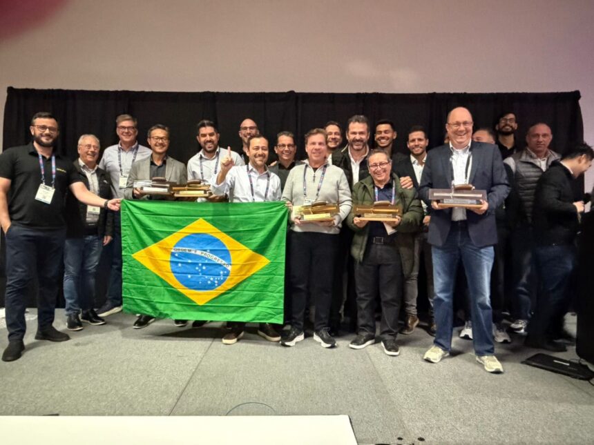 Equipe brasileira da Concreserv e parceiros celebram premiação internacional no Golden Trowel Awards 2025, em Las Vegas, segurando troféus e a bandeira do Brasil.