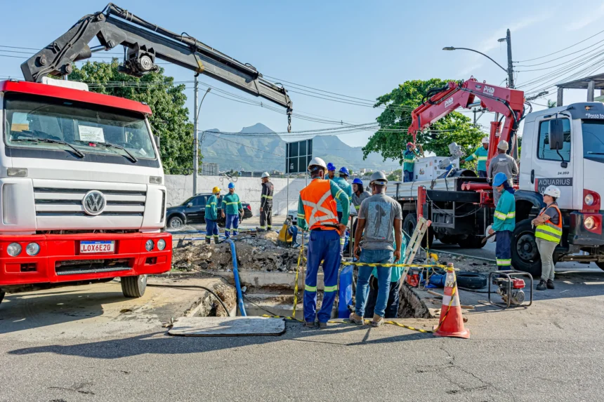 Equipe de trabalhadores da construção civil realiza obra de infraestrutura urbana com caminhões e equipamentos pesados em rua, representando o avanço das obras da Concrejato Engenharia em 2026.