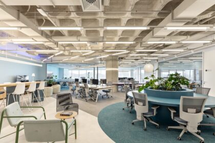 Escritório corporativo moderno entregue via Turnkey pela Space, com áreas colaborativas, estações de trabalho abertas, vegetação e teto de concreto aparente