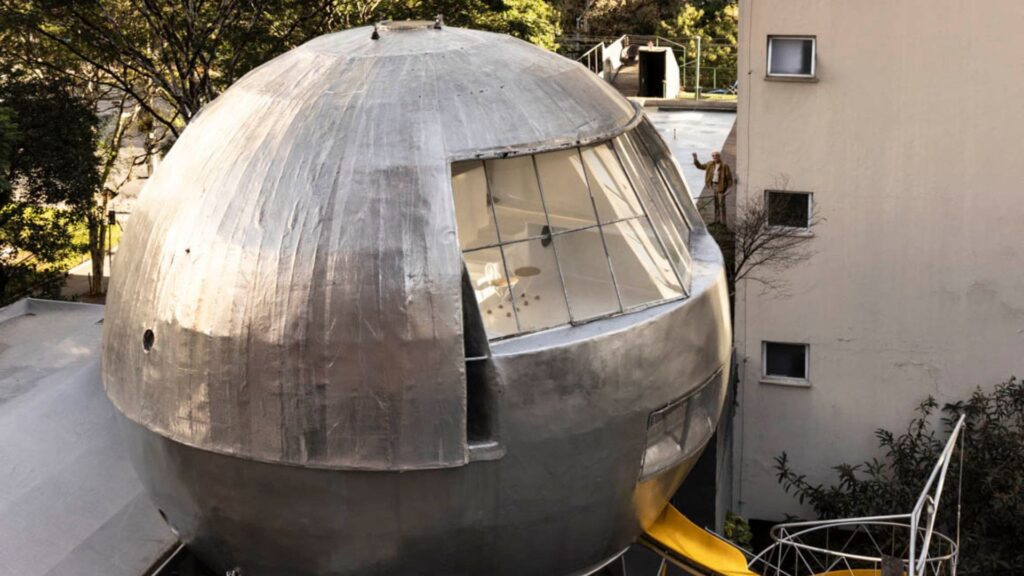 Vista aérea da Casa Bola, estrutura metálica esférica projetada por Eduardo Longo, cercada por prédios e áreas verdes no Jardim Paulistano, São Paulo.