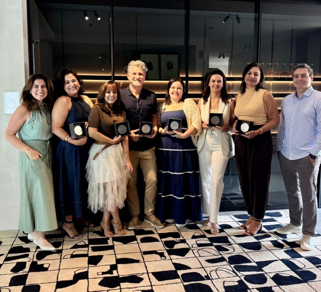 Karina e Fábio Alonso posam ao lado dos premiados da SCA Jardim Europa, incluindo Caroline, Sara, Frederico, Kênia, Juliana e Márcia, todos segurando troféus de reconhecimento em ambiente sofisticado.