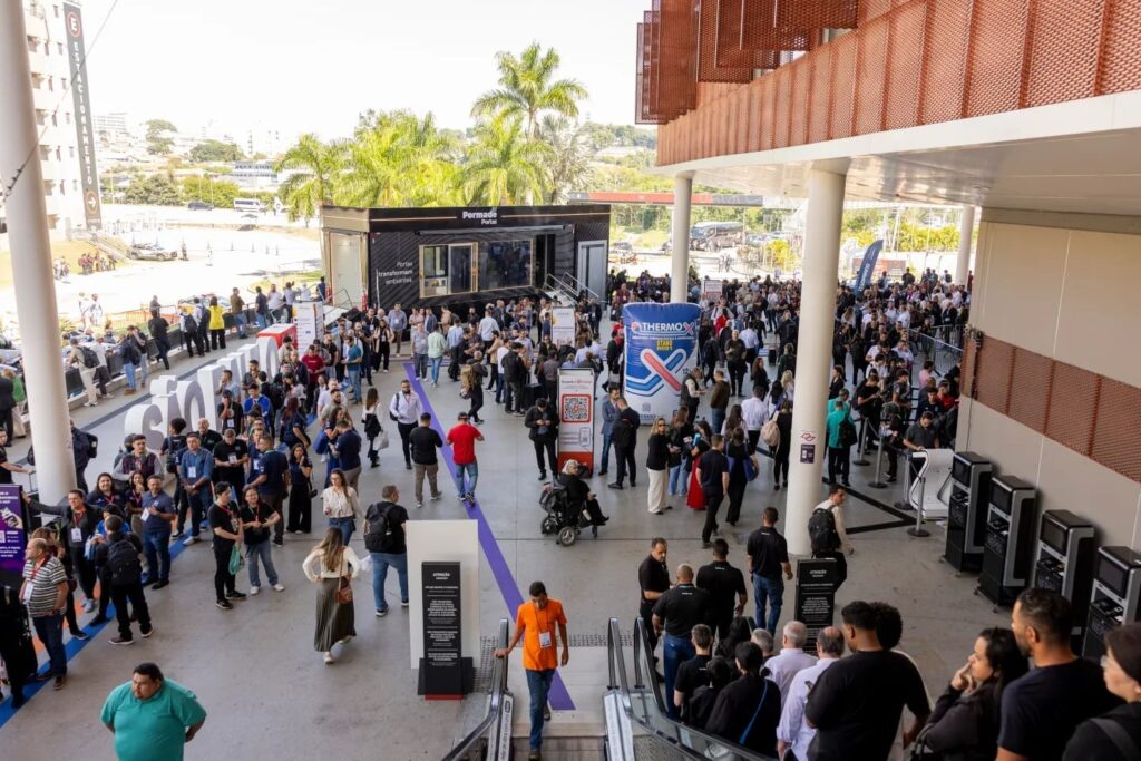 Fila de visitantes e profissionais aguardando o credenciamento na entrada da FEICON 2026, com grande movimentação e ambiente externo do São Paulo Expo ao fundo.