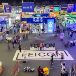 Vista panorâmica do pavilhão principal da FEICON 2026, com grande movimentação de visitantes e estandes de marcas líderes do setor da construção civil.