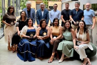 Equipe da SCA Jardim Europa posa com diretores e colaboradores premiados, exibindo troféus de Revenda Diamante, Melhor Gerente e Consultores Tops em ambiente moderno e iluminado.