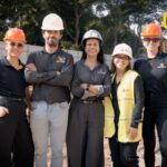 Equipe da Servter SP e do C3 - O Clube da Construção Civil posa sorridente no canteiro de obras do Arbórea Vista Jardim Europa, usando equipamentos de segurança e destacando a organização e profissionalismo no local.
