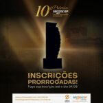 Troféu do 10º Prêmio Seconci-SP iluminado em dourado, com anúncio de inscrições prorrogadas até 04/05, sobre fundo escuro com silhueta de canteiro de obras.