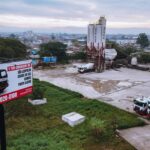 Vista aérea de usina de concreto da Concreserv em São Leopoldo, com caminhões betoneira e outdoor destacando a presença da empresa no Sul do Brasil.