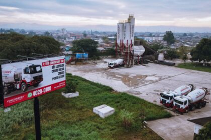 Vista aérea de usina de concreto da Concreserv em São Leopoldo, com caminhões betoneira e outdoor destacando a presença da empresa no Sul do Brasil.