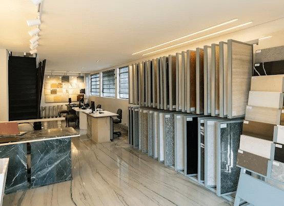 Showroom da Maison du Marbre com amostras de pedras naturais, bancadas em mármore e ambiente sofisticado, destacando variedade de materiais para projetos de alto padrão.