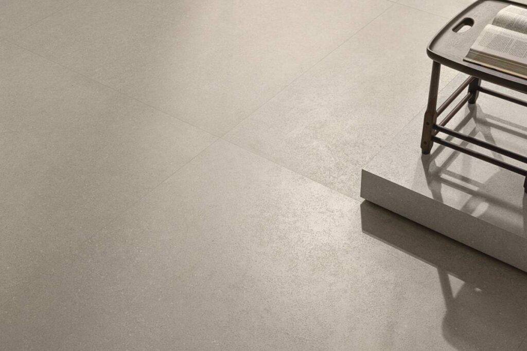 Detalhe do piso revestido com Kalks da Portobello, evidenciando textura sutil, acabamento elegante e tons neutros em ambiente contemporâneo.