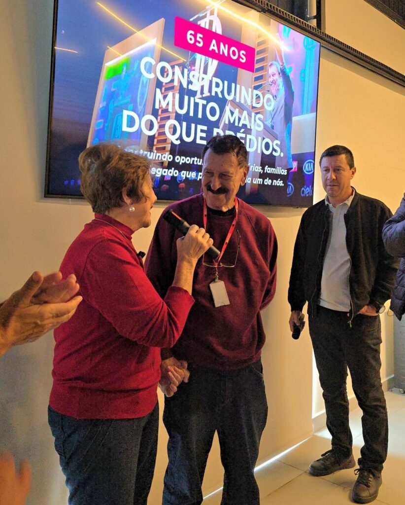 Sueli Pioli Bigucci homenageia Milton Bigucci com palavras emocionadas durante a celebração dos 65 anos de carreira na construção civil, em 19 de maio de 2026.