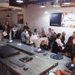 Participantes do 64° Almoço de Negócios do C3 reunidos em ambiente moderno, interagindo e trocando experiências em mesas redondas.