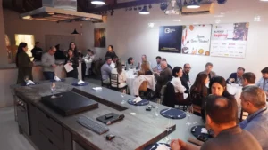 Participantes do 64° Almoço de Negócios do C3 reunidos em ambiente moderno, interagindo e trocando experiências em mesas redondas.