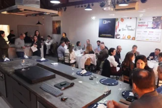 Participantes do 64° Almoço de Negócios do C3 reunidos em ambiente moderno, interagindo e trocando experiências em mesas redondas.