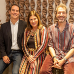 Marcello Anthony, Tatiana Mandelli e Francesco Maccapani Missoni sorrindo juntos durante a abertura da loja Tidelli em Lisboa, sentados em frente a um painel de cordas artesanais.
