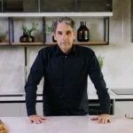 Arquiteto Luis Café, líder da LCVC Arquitetura e Interiores, em ambiente sofisticado de cozinha contemporânea, representando inovação e alto padrão em projetos residenciais.