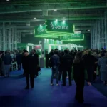 Público circulando e interagindo no Pavilhão C do Transamérica Expo Center durante o Senior Experience 2026, com destaque para o estande iluminado da Senior Sistemas ao fundo.