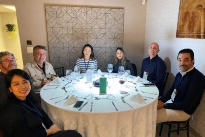 Grupo de profissionais da construção civil reunidos ao redor de uma mesa redonda durante o 65° Almoço de Negócios do C3, em ambiente elegante e descontraído.