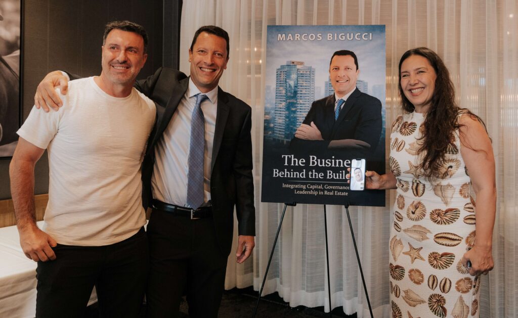 Marcelo e Roberta Bigucci surpreendem o irmão Marcos Bigucci durante o lançamento do livro “The Business Behind the Buildings” em Orlando, Flórida, em junho de 2026.