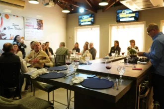 Profissionais da construção civil participam de momento de integração e networking durante o 66° Almoço de Negócios do C3, em ambiente moderno, com mesas redondas e apresentação ao vivo.